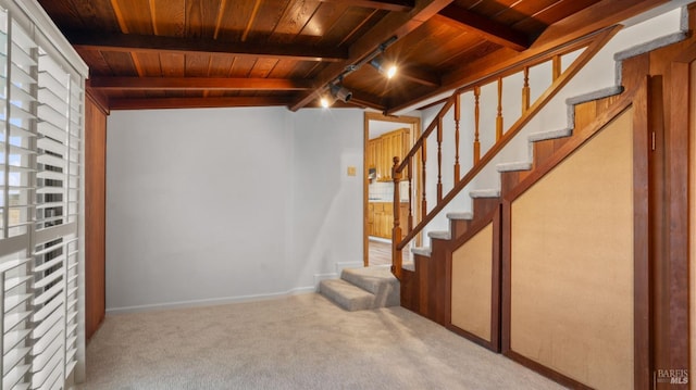 basement with rail lighting, wooden ceiling, and light carpet