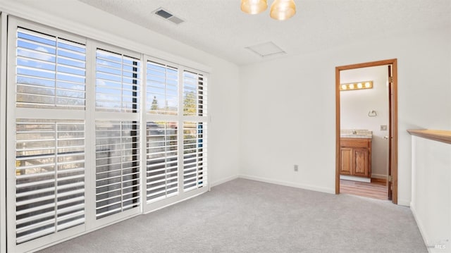 carpeted empty room featuring a textured ceiling