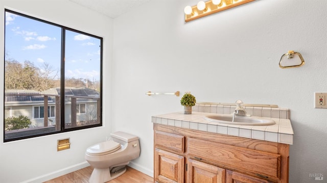 bathroom featuring vanity, toilet, and wood-type flooring