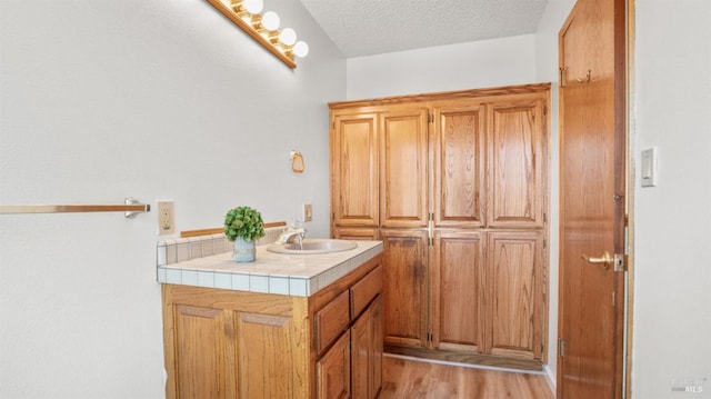 bathroom featuring hardwood / wood-style floors, vanity, and a textured ceiling