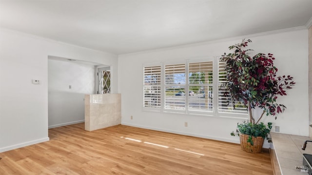 unfurnished room with light wood-type flooring and crown molding