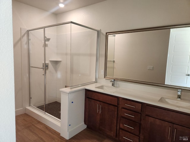 bathroom featuring hardwood / wood-style floors, vanity, and a shower with shower door