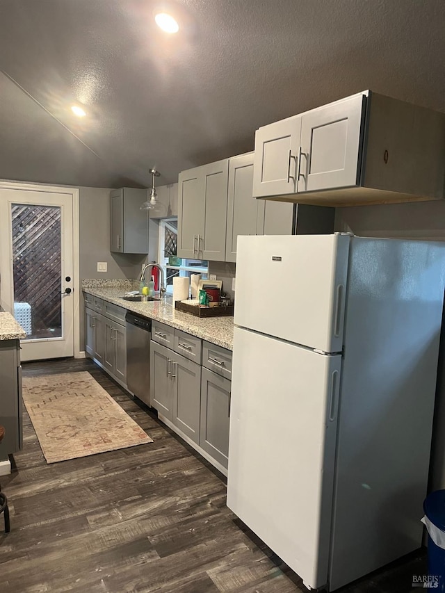 kitchen with gray cabinetry, dishwasher, light stone counters, dark hardwood / wood-style floors, and white fridge