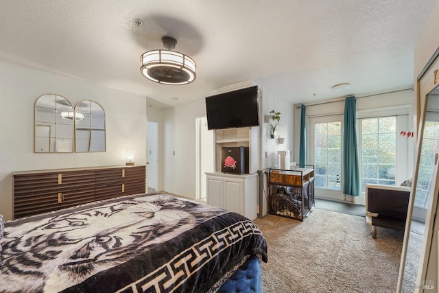 bedroom featuring a textured ceiling, carpet flooring, and access to exterior