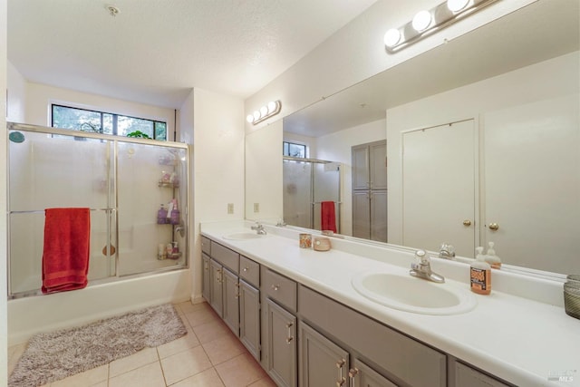 bathroom featuring double vanity, tile patterned flooring, enclosed tub / shower combo, and a sink