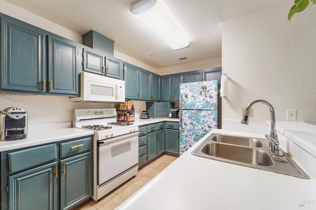 kitchen with light countertops, a textured wall, visible vents, a sink, and white appliances