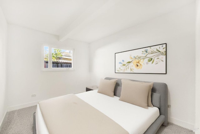 carpeted bedroom with beamed ceiling