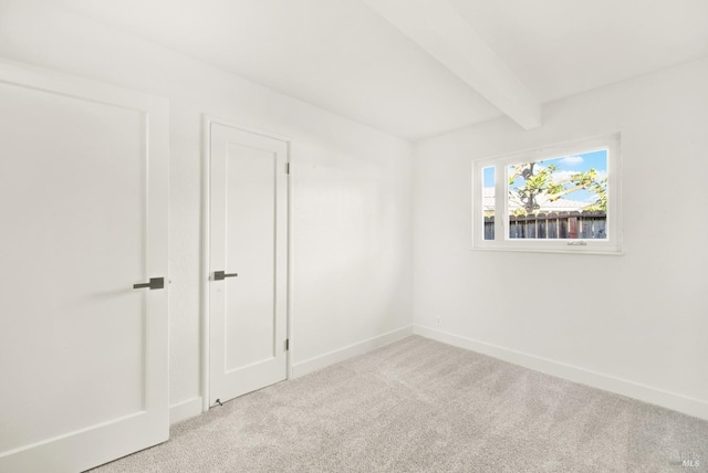 unfurnished room with light carpet and beam ceiling