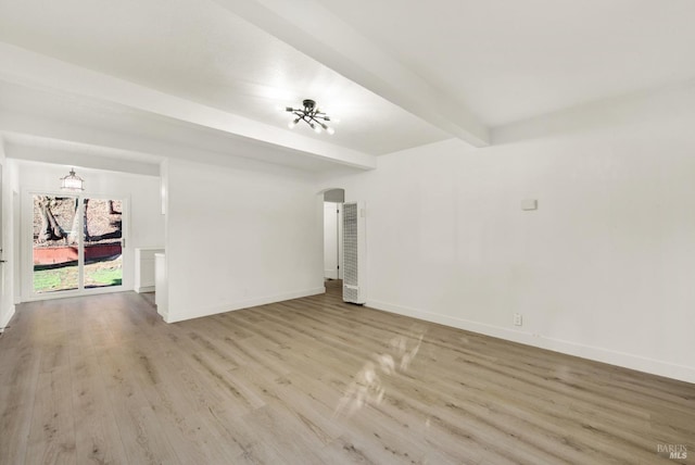 empty room with beamed ceiling and light hardwood / wood-style floors