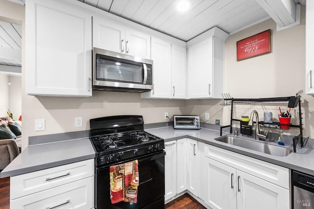 kitchen with sink, white cabinetry, appliances with stainless steel finishes, and dark hardwood / wood-style floors