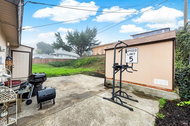 view of patio with area for grilling and a storage shed