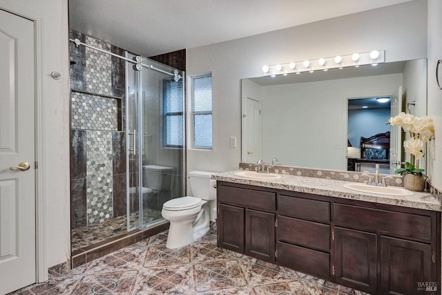 bathroom featuring walk in shower, vanity, a textured ceiling, and toilet