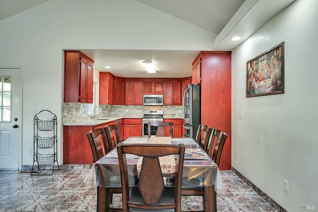 dining space featuring lofted ceiling and sink