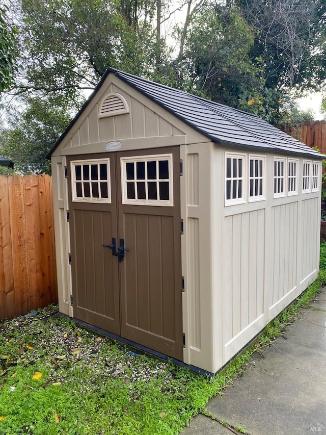 view of shed featuring fence