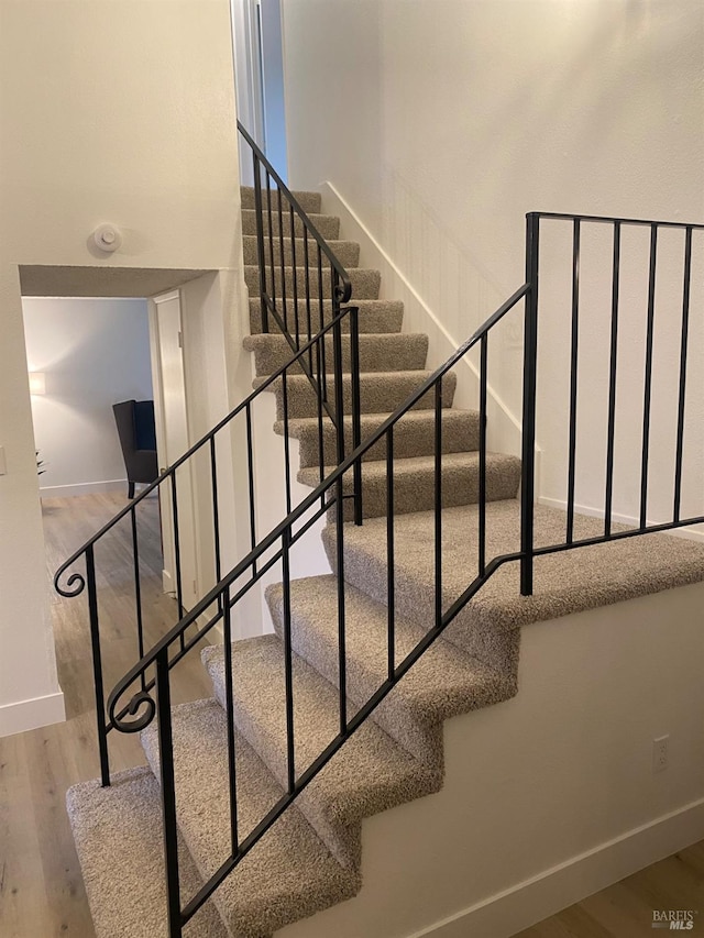 stairway with baseboards and wood finished floors