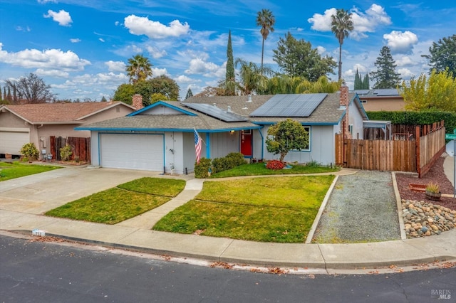 single story home with a garage, a front yard, and solar panels