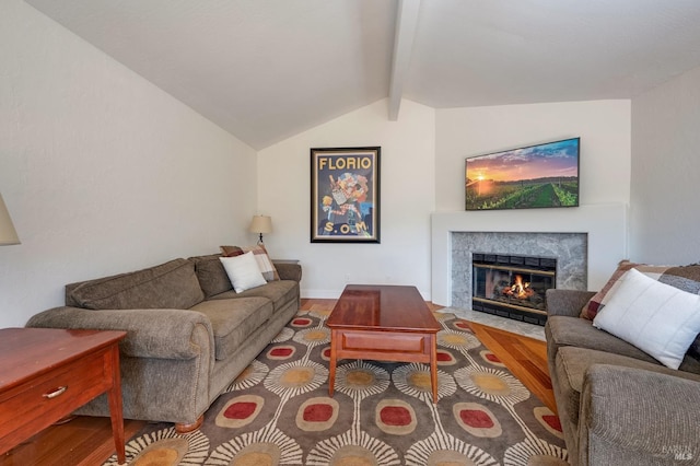 living room featuring a fireplace, vaulted ceiling with beams, and hardwood / wood-style flooring