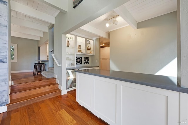 interior space featuring beamed ceiling, white cabinetry, hardwood / wood-style floors, and wood ceiling