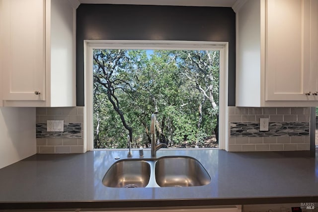 kitchen with dishwasher, white cabinetry, sink, and tasteful backsplash