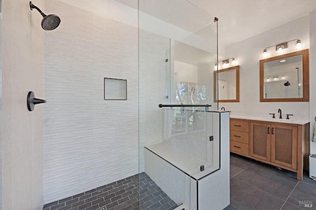 bathroom with a tile shower, tile patterned flooring, and vanity