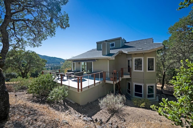 rear view of property with a deck with mountain view