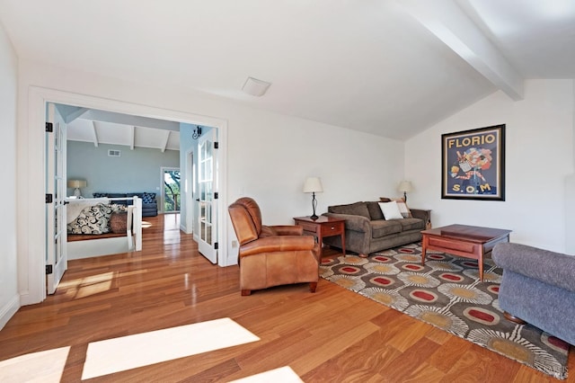 living room with hardwood / wood-style flooring, vaulted ceiling with beams, and french doors