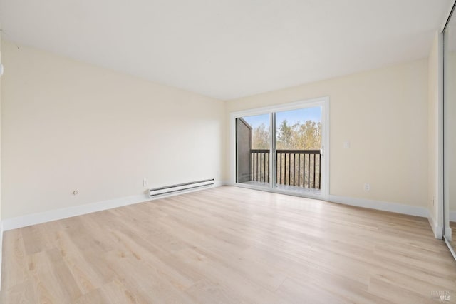 empty room featuring baseboard heating and light hardwood / wood-style flooring