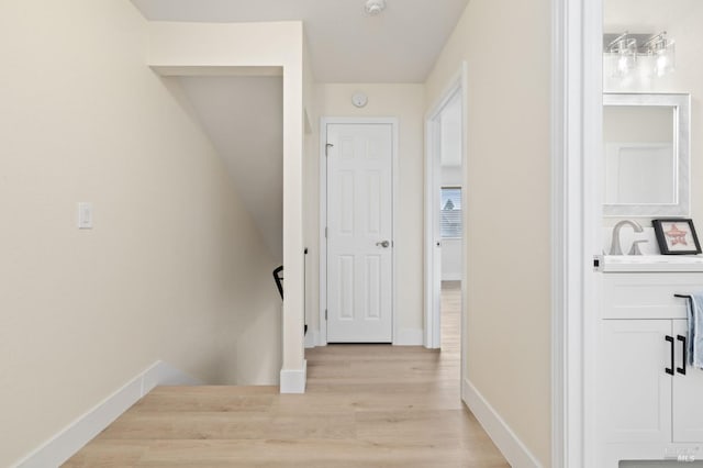 hallway with sink and light hardwood / wood-style flooring