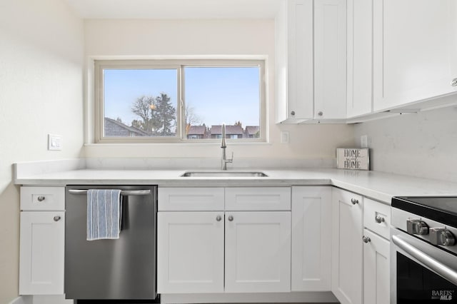 kitchen featuring sink, range, white cabinets, and stainless steel dishwasher