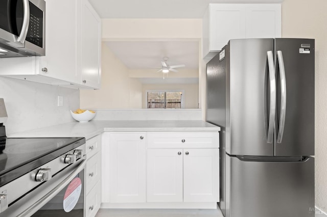 kitchen with appliances with stainless steel finishes, ceiling fan, and white cabinets