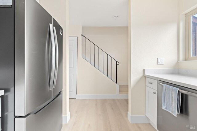 kitchen with white cabinetry, light hardwood / wood-style floors, and appliances with stainless steel finishes