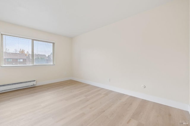 spare room with light hardwood / wood-style flooring and a baseboard heating unit