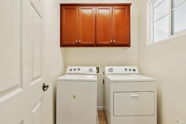 washroom featuring cabinets, washer and dryer, and light tile patterned flooring