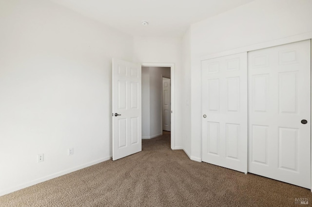 unfurnished bedroom featuring carpet and a closet