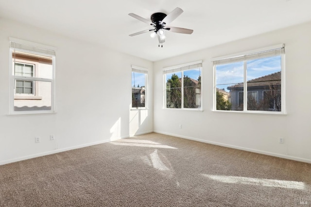 carpeted empty room with a wealth of natural light and ceiling fan