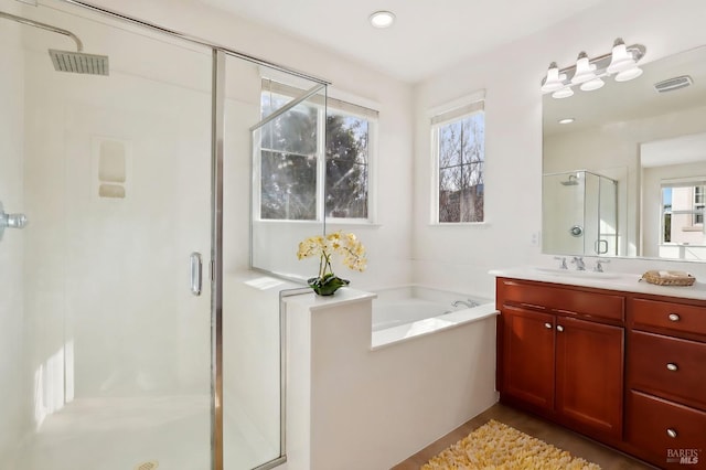 bathroom with vanity and shower with separate bathtub