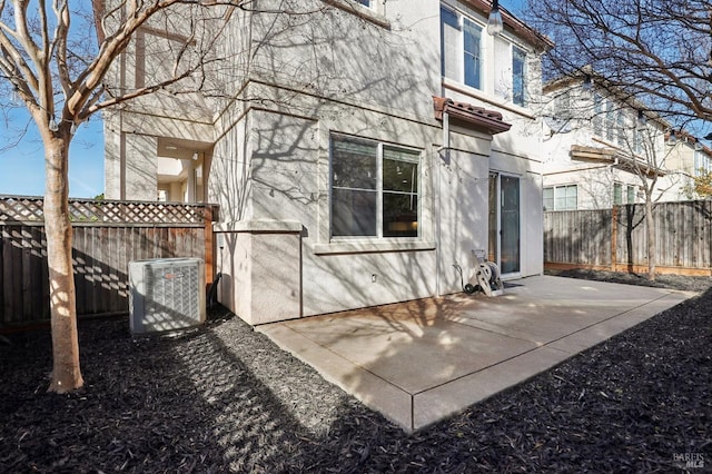 back of property with cooling unit and a patio