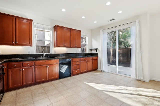 kitchen with stove, black dishwasher, dark stone counters, and sink