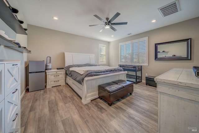 bedroom with ceiling fan, white refrigerator, and light wood-type flooring