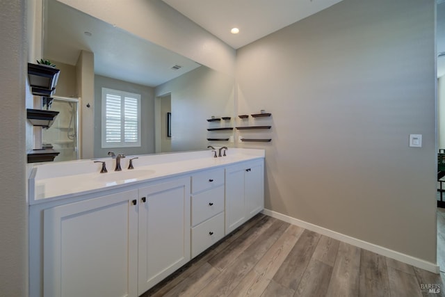 bathroom featuring walk in shower, wood-type flooring, and vanity