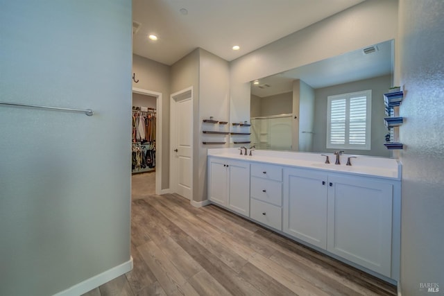 bathroom featuring hardwood / wood-style flooring, walk in shower, and vanity