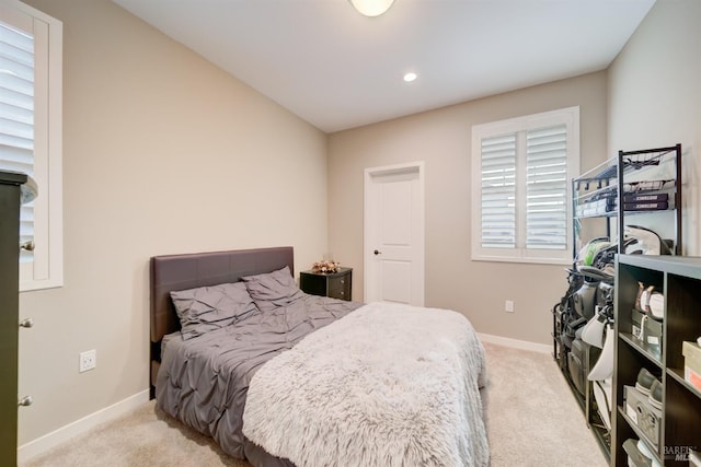 bedroom with light colored carpet and multiple windows