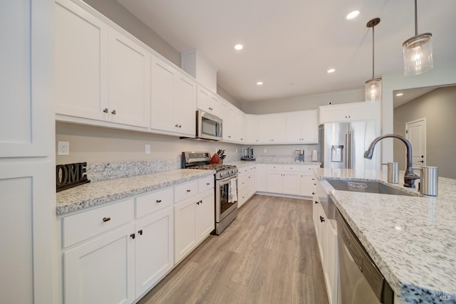 kitchen with stainless steel appliances, white cabinets, decorative light fixtures, and sink