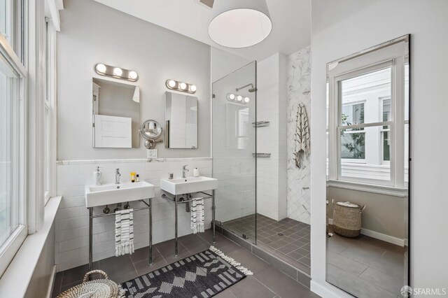 bathroom with sink, tile walls, tile patterned floors, and a shower with shower door