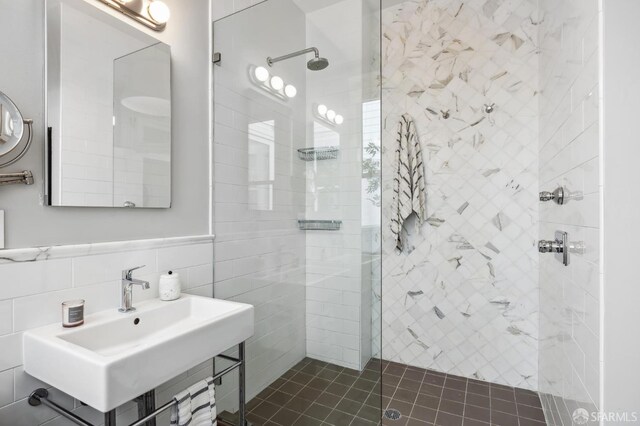 bathroom with tile walls, backsplash, sink, and a tile shower