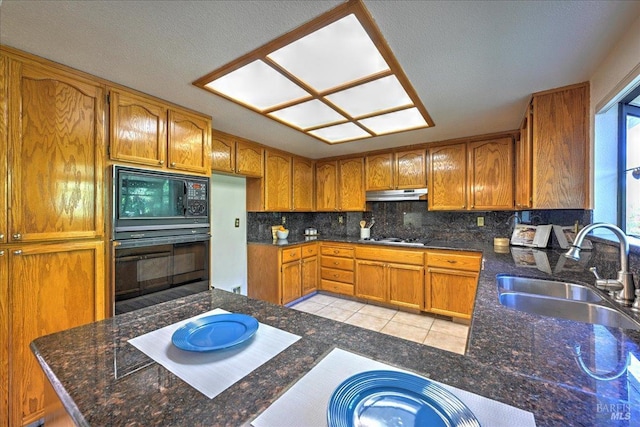 kitchen with kitchen peninsula, backsplash, black appliances, sink, and light tile patterned flooring