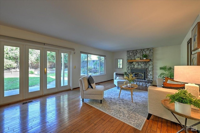 living room featuring a fireplace, wood-type flooring, and french doors