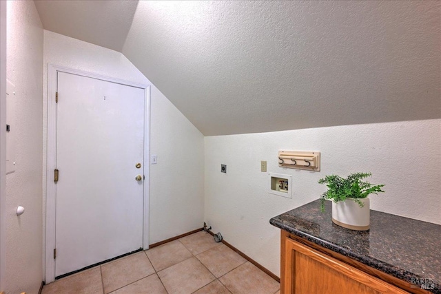 washroom featuring hookup for an electric dryer, washer hookup, a textured ceiling, and light tile patterned floors