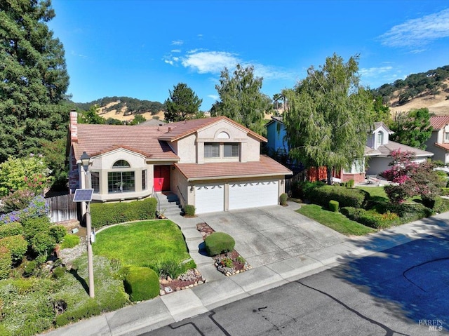 view of front facade featuring a mountain view, a garage, and a front lawn