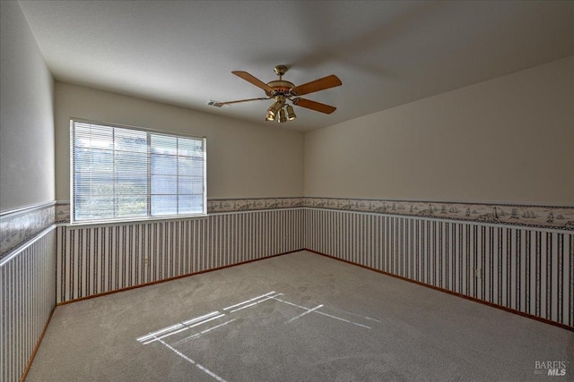 empty room featuring light colored carpet and ceiling fan